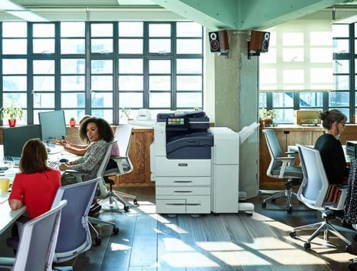 Equipe au travail dans un Open space avec l'imprimante monochrome Xerox® Série VersaLink® B7100