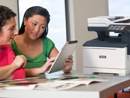 Twee vrouwen gebruiken een tablet voor een Xerox® VersaLink B415 multifunctionele printer